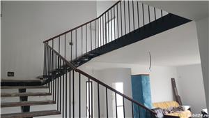 Scară metalică cu trepte din lemn masiv lăcuite și cu o balustradă metalică vopsită