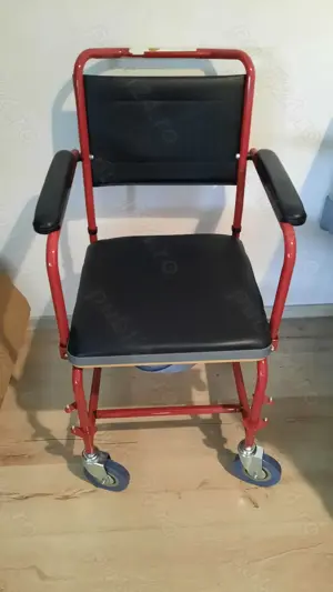 Scaun cu rotile cu vas de wc incorporat.