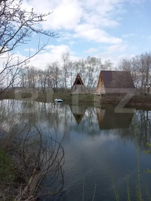 Teren cu iaz amenajat și două cabane A-frame în construcție