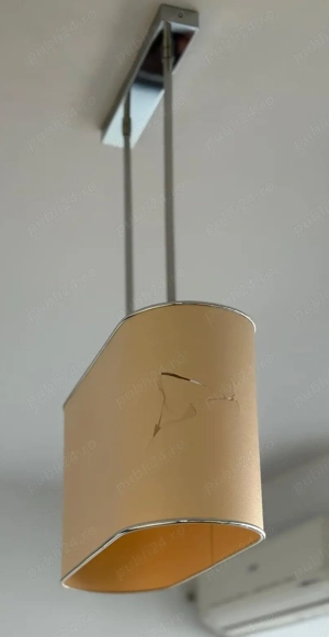 Lustra cu abajurul spart pe o latura