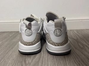 Nike Jordan Spizike Low în varianta de culoare alb gri, având detalii argintii pe călcâi