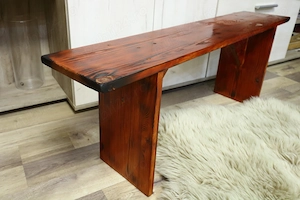 Băncuță din lemn masiv, realizată manual, cu un design rustic și aspect vintage.